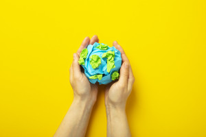 top-view-hands-holding-planet-on-yellow-background